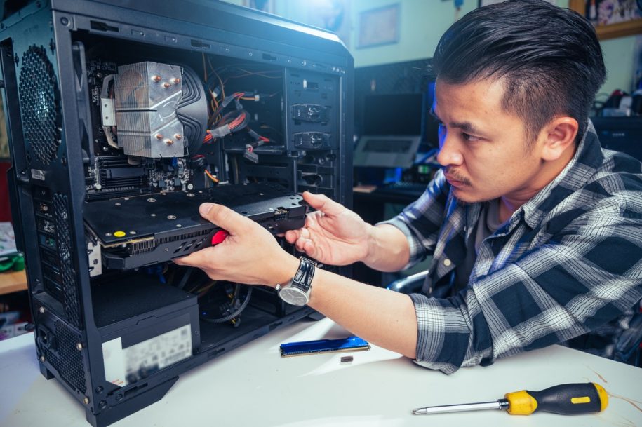 Computer technician diagnosing hardware at a pc repair shop